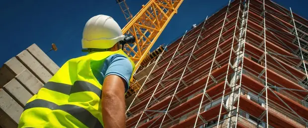 Operario observando andaimes em uma obra conduzida sem coordenacao BIM